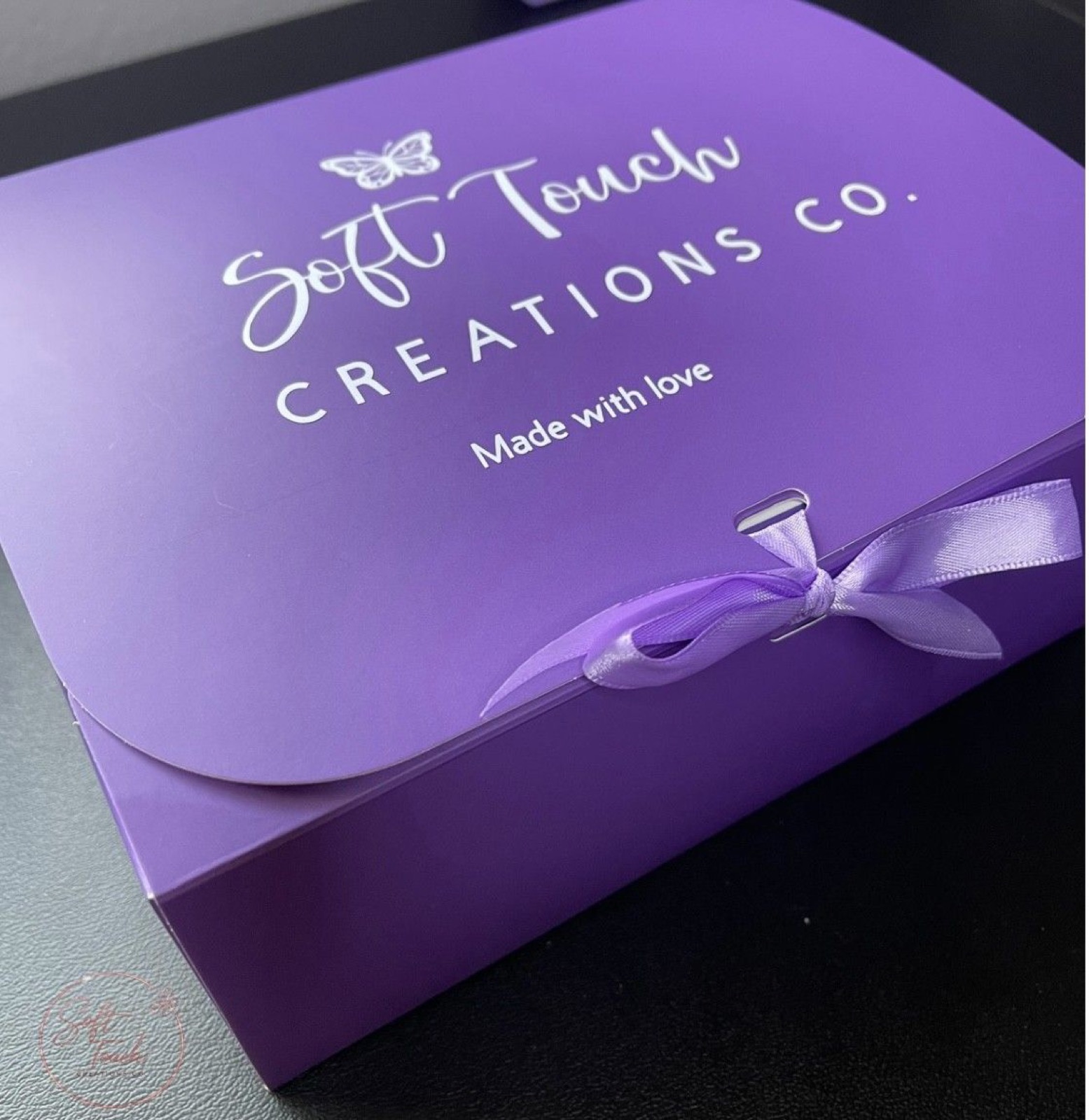 Soft Touch Creations branded purple closing gift box with satin ribbon
